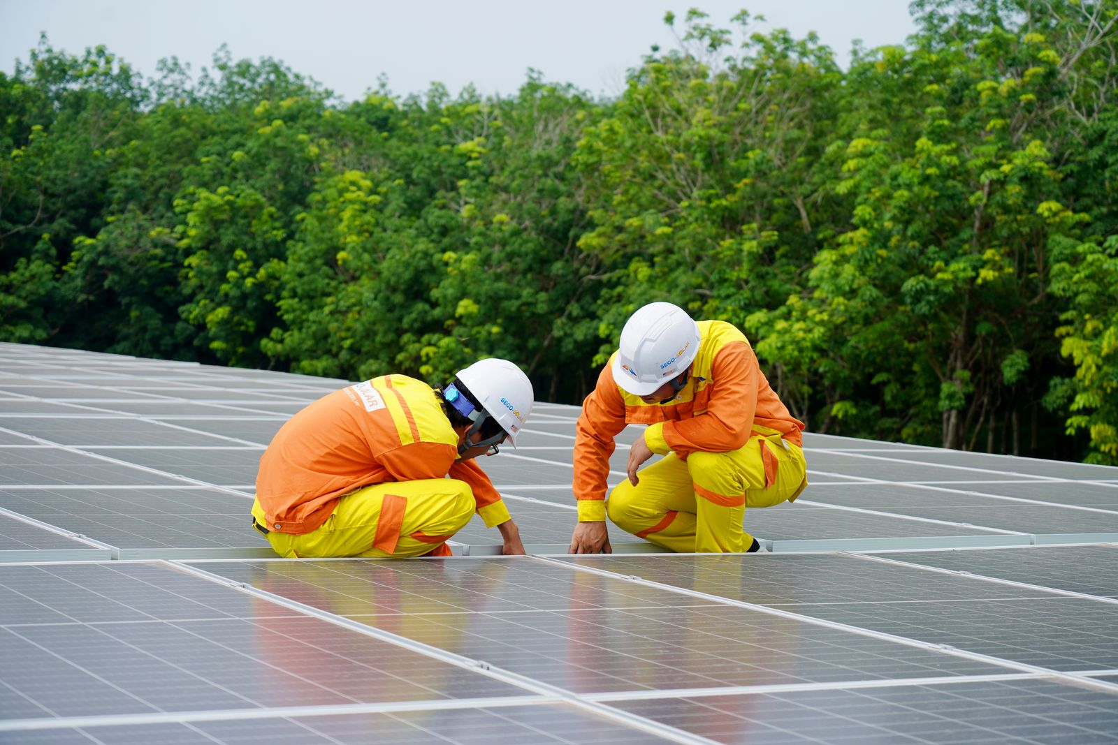 Technicians installing solar panels on site