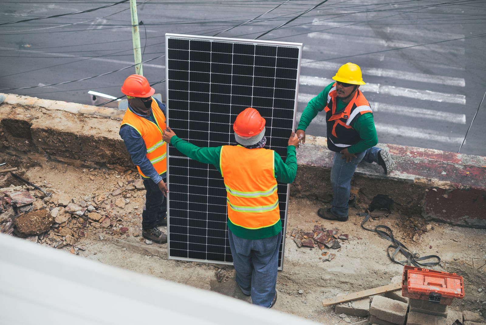 Workers carrying a solar panel on site